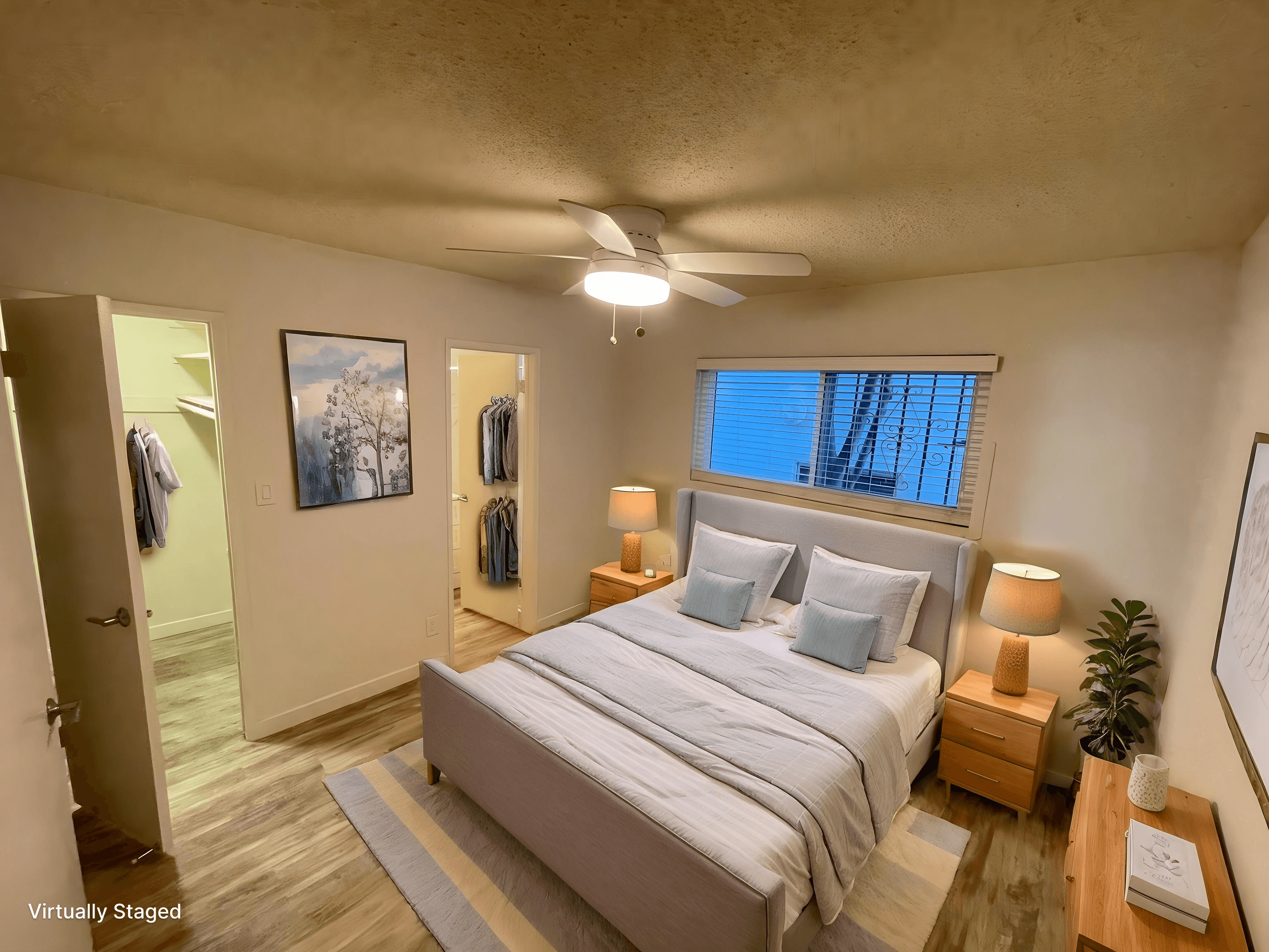 A bedroom with a bed, nightstands, and a ceiling fan.